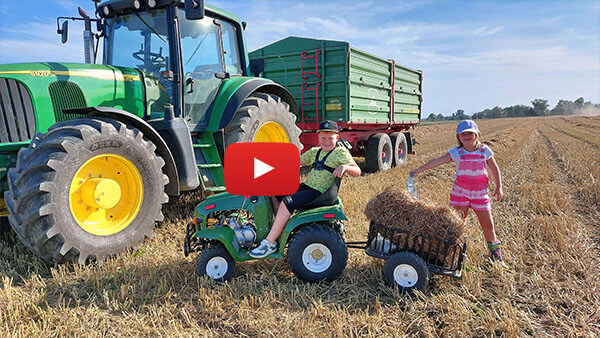 Children collect straw during harvest with a 110 mini tractor from Nitro Motors